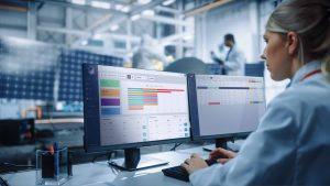 Production team members using POET OEE dashboard on PC to view reports of the manufacturing factory on operational excellence software